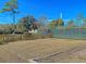 Community tennis court next to wooden fence with landscaping and mature trees at 2011 N Hwy 17 # 2200H, Mount Pleasant, SC 29466