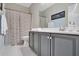 This bathroom features gray cabinetry, a striped shower curtain, and a contrasting tile floor at 2038 Sea Water Dr, James Island, SC 29412