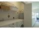 Functional laundry room includes a washer, dryer, and shelving for storage at 204 Michigan Ave # C-5 - 11, Folly Beach, SC 29439