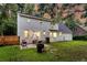 Rear exterior view featuring a patio with seating, a well-maintained lawn, and a home with painted brick at 205 Towhee Dr, Summerville, SC 29485