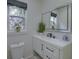 Bathroom with a modern vanity, decorative mirror, and decorative flowers in a vase next to a decorated window at 205 Towhee Dr, Summerville, SC 29485