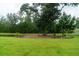 Lush green backyard with a mature trees and natural landscape elements creates a serene and private outdoor space at 2408 Bent Oak Rd, Mount Pleasant, SC 29466