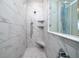 Beautiful marble tile shower with built-in shelves and mosaic tile floor at 2408 Bent Oak Rd, Mount Pleasant, SC 29466