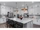 Modern kitchen with an island, stainless steel appliances, white cabinets, and stylish pendant lighting at 2408 Bent Oak Rd, Mount Pleasant, SC 29466
