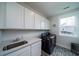 Bright laundry room with white cabinets, designer flooring, and a window at 2408 Bent Oak Rd, Mount Pleasant, SC 29466