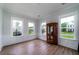 Bright living room with hardwood floors, three large windows, and traditional wood cabinet at 2408 Bent Oak Rd, Mount Pleasant, SC 29466