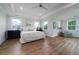 Bright primary bedroom with tray ceiling, hardwood floors, and large windows at 2408 Bent Oak Rd, Mount Pleasant, SC 29466