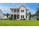 Spacious backyard featuring a two-story white home with a screened porch and grilling area, perfect for outdoor entertaining at 2408 Bent Oak Rd, Mount Pleasant, SC 29466