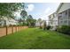 Large grassy backyard with a wood fence, trampoline, string lights, and mature trees at 2828 Wagner Way, Mount Pleasant, SC 29466