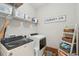 Functional laundry room with modern appliances, shelving, and decorative 