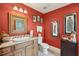 Red bathroom with vanity, granite countertop, framed mirror, toilet, and decorative artwork at 2834 Parkers Landing Rd, Mount Pleasant, SC 29466