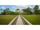 Grand home nestled among trees, accessed by a long wooden walkway through lush marshland, offering privacy and charm at 2834 Parkers Landing Rd, Mount Pleasant, SC 29466
