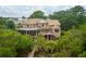 Stunning multi-story home featuring a metal roof, brick exterior, and expansive screened-in deck overlooking lush greenery at 2834 Parkers Landing Rd, Mount Pleasant, SC 29466