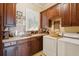 Laundry room with wood cabinets, tile countertop, sink, window, and washer and dryer at 2834 Parkers Landing Rd, Mount Pleasant, SC 29466
