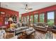 Cozy living room featuring wood-trimmed red walls, plush sofas, zebra ottoman, and access to a balcony with a view at 2834 Parkers Landing Rd, Mount Pleasant, SC 29466