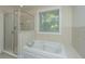 Spa-like bathroom featuring a jetted tub, separate shower and window at 3005 Macbeth Creek Dr, Charleston, SC 29414
