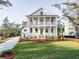 Stunning two-story white home with inviting double porches and beautifully landscaped front yard at 3898 Summerton Street Dr, Mount Pleasant, SC 29466