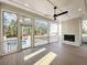 Screened patio with fireplace features a ceiling fan and leads to a pristine pool, perfect for outdoor relaxation at 3898 Summerton Street Dr, Mount Pleasant, SC 29466