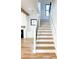 Bright staircase showcasing wood treads, white risers, and iron railings leading to the upper level of this modern home at 3898 Summerton Street Dr, Mount Pleasant, SC 29466