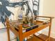 Stylish bar cart featuring liquor bottles, glassware, and a shaker against an abstract artwork backdrop at 4 Beaufain St # 207, Charleston, SC 29401