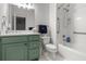 Well-lit bathroom features a green vanity, white tile, and accessible grab bars at 4 Beaufain St # 207, Charleston, SC 29401