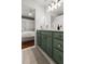 Bathroom featuring a green vanity with a marble countertop, a mirror, and tiled floors at 4 Beaufain St # 207, Charleston, SC 29401