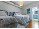 Bright bedroom featuring two cozy beds, hardwood floors, and updated ensuite bathroom at 4 Beaufain St # 207, Charleston, SC 29401