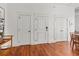 Hallway showcasing white doors with black hardware and wood floors, adjacent to kitchen bar at 4 Beaufain St # 207, Charleston, SC 29401