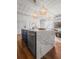 Kitchen island with marble countertop and brass faucet, offering a stylish workspace and a view into the living area at 4 Beaufain St # 207, Charleston, SC 29401
