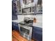 Close-up of the oven and stovetop, which is part of a kitchen with stainless steel appliances and custom blue cabinets at 4 Beaufain St # 207, Charleston, SC 29401