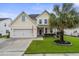 Charming two-story home featuring a well-manicured lawn, two-car garage, and a classic blue front door at 411 Topcrest Ln, Moncks Corner, SC 29461