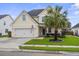 Charming two-story home featuring a well-manicured lawn, two-car garage, and a classic blue front door at 411 Topcrest Ln, Moncks Corner, SC 29461