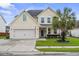 Charming two-story home featuring a well-manicured lawn, two-car garage, and a classic blue front door at 411 Topcrest Ln, Moncks Corner, SC 29461