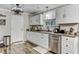 Well-lit kitchen features stainless steel dishwasher and white cabinets with wood-look floors at 414 Birch Ave, Goose Creek, SC 29445