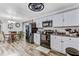 Open-concept kitchen with white cabinetry, black appliances, and wood-look floors, with great dining space at 414 Birch Ave, Goose Creek, SC 29445