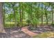 Scenic backyard featuring a charming brick path, lush greenery, and mature trees at 4272 Persimmon Woods Dr, Charleston, SC 29420