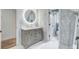 Well-designed bathroom with a round mirror, under vanity storage, and stylish wallpaper at 4272 Persimmon Woods Dr, Charleston, SC 29420