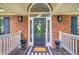 Front door entrance with a beautiful wreath, decorative lighting and planters, and a striped mat at 4272 Persimmon Woods Dr, Charleston, SC 29420