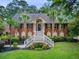 Beautiful brick home features a grand entrance with dual staircases and well-manicured landscaping at 4272 Persimmon Woods Dr, Charleston, SC 29420