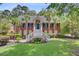 Charming two-story brick home with a manicured lawn, white columns, and palm trees at 4272 Persimmon Woods Dr, Charleston, SC 29420