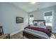 This bedroom features a wood frame bed, wood floors, light-grey walls, and two windows for ample natural light at 436 Ripple Park Dr, Summerville, SC 29486