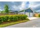 View of a 2-car garage and screened-in porch with blue siding and white trim surrounded by a beautiful fenced yard at 436 Ripple Park Dr, Summerville, SC 29486
