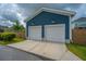 Two-car garage with white garage doors, blue siding, lights, and a concrete driveway on a cloudy day at 436 Ripple Park Dr, Summerville, SC 29486
