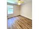 Neutral bedroom with wood flooring, shelving, a window and a ceiling fan at 4816 Cane Pole Ln, Summerville, SC 29485