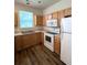 Functional kitchen featuring wood cabinets, white appliances, and durable laminate flooring at 4816 Cane Pole Ln, Summerville, SC 29485