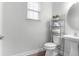 Bright bathroom with a pedestal sink, shelving unit, and stylish accessories at 5242 E Dolphin St, North Charleston, SC 29405