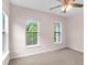 Bedroom featuring neutral walls, carpet, a ceiling fan and two bright windows at 5242 E Dolphin St, North Charleston, SC 29405