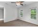 Bright bedroom with neutral walls, carpet, a ceiling fan and two windows at 5242 E Dolphin St, North Charleston, SC 29405