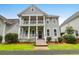 This charming two story home has a double porch, gray siding and well manicured landscaping at 5242 E Dolphin St, North Charleston, SC 29405