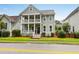 Charming two-story home featuring a double porch, neutral siding and a beautifully landscaped yard at 5242 E Dolphin St, North Charleston, SC 29405